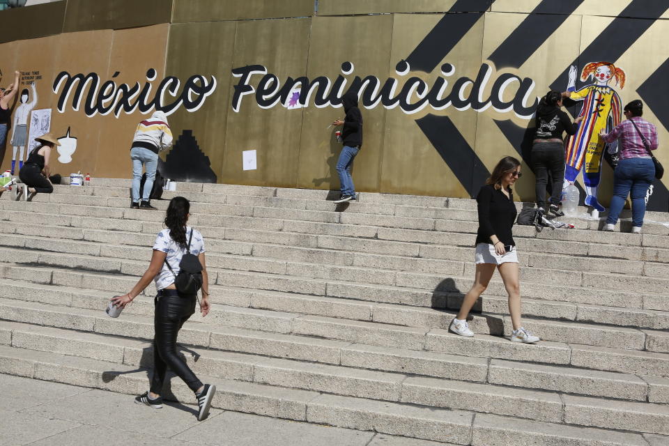 Grupos de mujeres opuestas a la violencia de género pintan consignas en las tablas que rodean el monumento del Ángel de la Independencia en la Ciudad de México, el domingo 24 de noviembre de 2019. (AP Foto/Ginnette Riquelme)