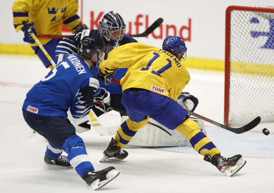 Finland's Mikko Kokkonen, left, and Finland's Justus Annunen, center, fail to stop Sweden's Samuel Fagemo, right, from scoring his sides second goal during the U20 Ice Hockey Worlds bronze medal match between Finland and Sweden in Ostrava, Czech Republic, Sunday, Jan. 5, 2020. (AP Photo/Petr David Josek)