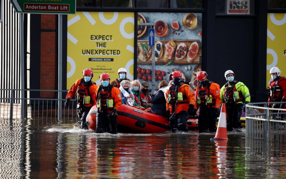 residents being taken away by boat - REUTERS/Phil Noble