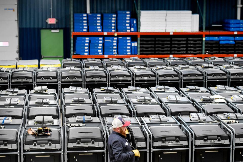 Tim Roberts, a Buncombe County electrical specialist, works to connect 106 voting machines to power January 3, 2020.