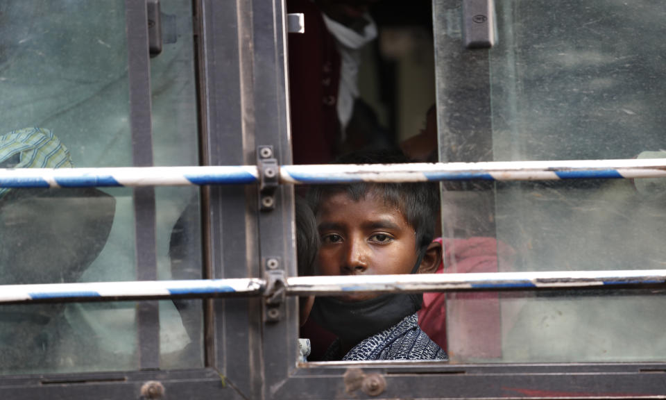 The son of a migrant daily wage laborer looks out a bus window bus as he travels to his hometown following a lockdown amid concern over spread of coronavirus in New Delhi, India, Friday, March 27, 2020. Some of India's legions of poor and others suddenly thrown out of work by a nationwide stay-at-home order began receiving aid on Thursday, as both public and private groups worked to blunt the impact of efforts to curb the coronavirus pandemic. The measures that went into effect Wednesday, the largest of their kind in the world, risk heaping further hardship on the quarter of the population who live below the poverty line and the 1.8 million who are homeless. (AP Photo/Manish Swarup)