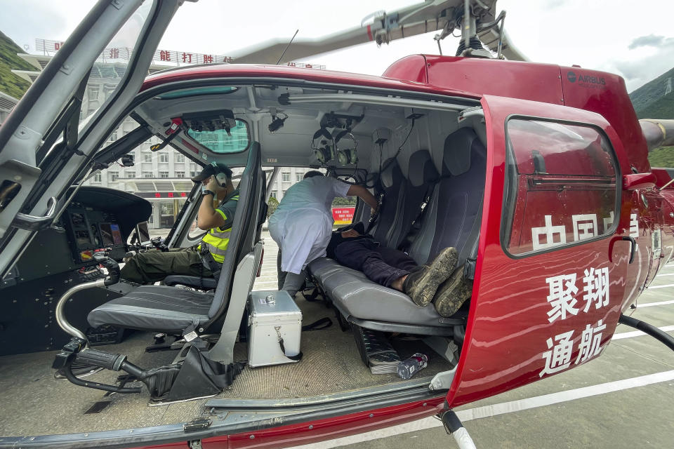 In this photo released by Xinhua News Agency, Gan Yu, a hydropower station worker who had gone missing for 17 days after an earthquake, lies on the backseat of a helicopter after he was found and evacuated to Luding County in southwestern China's Sichuan Province on Wednesday, Sept. 21, 2022 (Xinhua via AP)