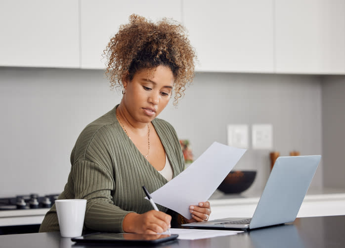 A woman calculating how much she could save on taxes by filing either as a head of household or single.