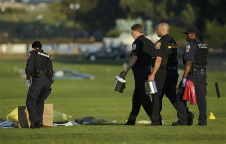 Law enforcement officials collect eveidence at the scene where a man set himself on fire within sight of the U.S. Capitol building on the U.S. National Mall in Washington, October 4, 2013. REUTERS/Gary Cameron