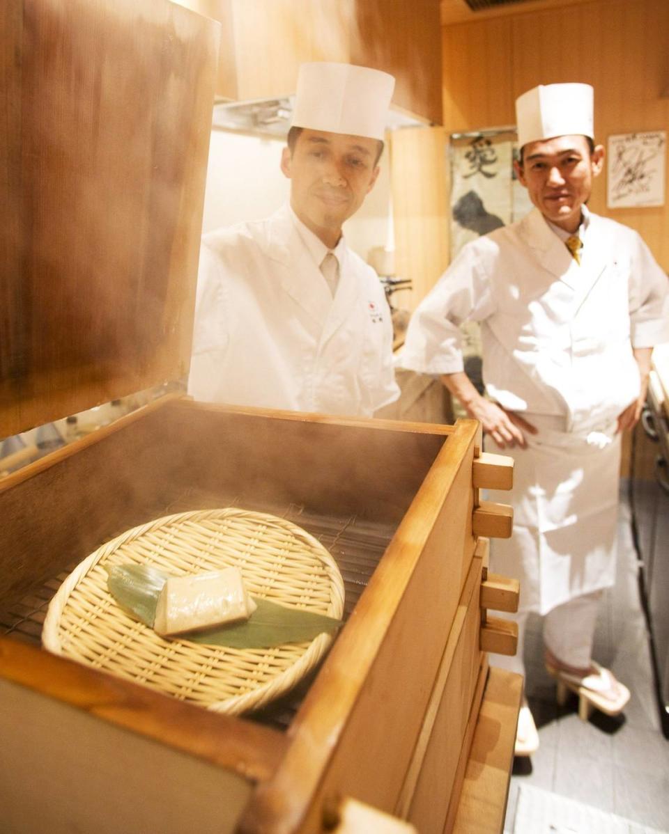 Fotografía del jefe de cocina japonés Hiroyuki Naka (dcha) esperando la terminación de un plato al vapor en su restaurante de Osaka, Japón. La cocina al vapor es la más sana que existe.