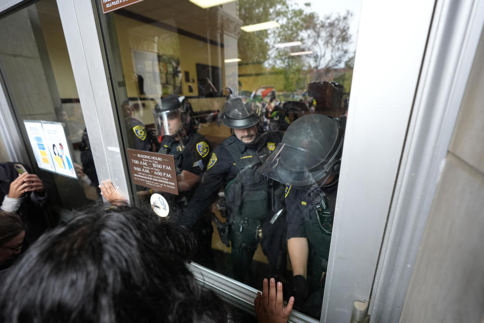 Police block a doorway to pro-Palestinian demonstrators at Dodd Hall on the UCLA campus on Thursday, May 23, 2024, in Los Angeles. (AP Photo/Ryan Sun)