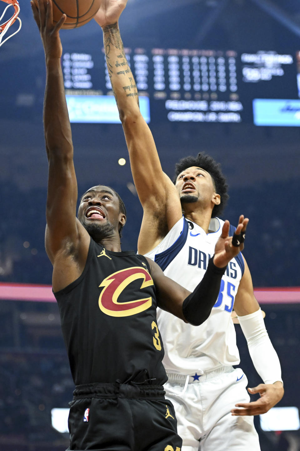 Dallas Mavericks forward Christian Wood, right, blocks a shot by Cleveland Cavaliers guard Caris LeVert, left, during the first half of an NBA basketball game, Saturday, Dec. 17, 2022, in Cleveland. (AP Photo/Nick Cammett)