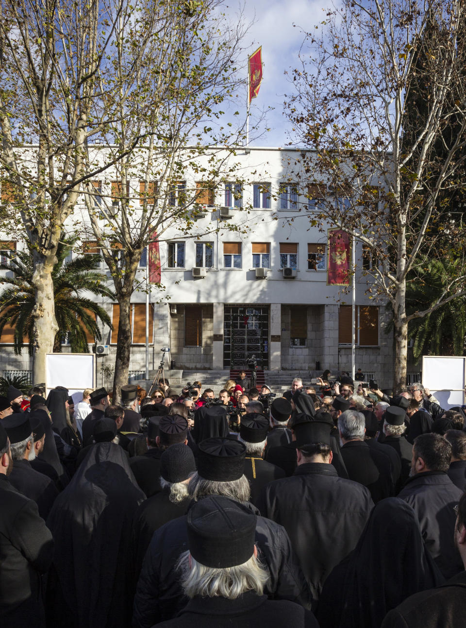 Serbian Orthodox Church clergy in Montenegro gather in front of parliament building as they protest the planned adoption of a religious law that they say will pave the way to strip the church of its property, in Podgorica, Montenegro, Tuesday, Dec. 24, 2019. Montenegro's pro-Western president has accused the church of promoting pro-Serb policies in Montenegro and seeking to undermine the country's statehood since it split from Serbia in 2006. (AP Photo/Risto Bozovic)