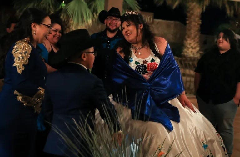 Karina laughs with her family before making her announced entrance at her quinceañera celebration.