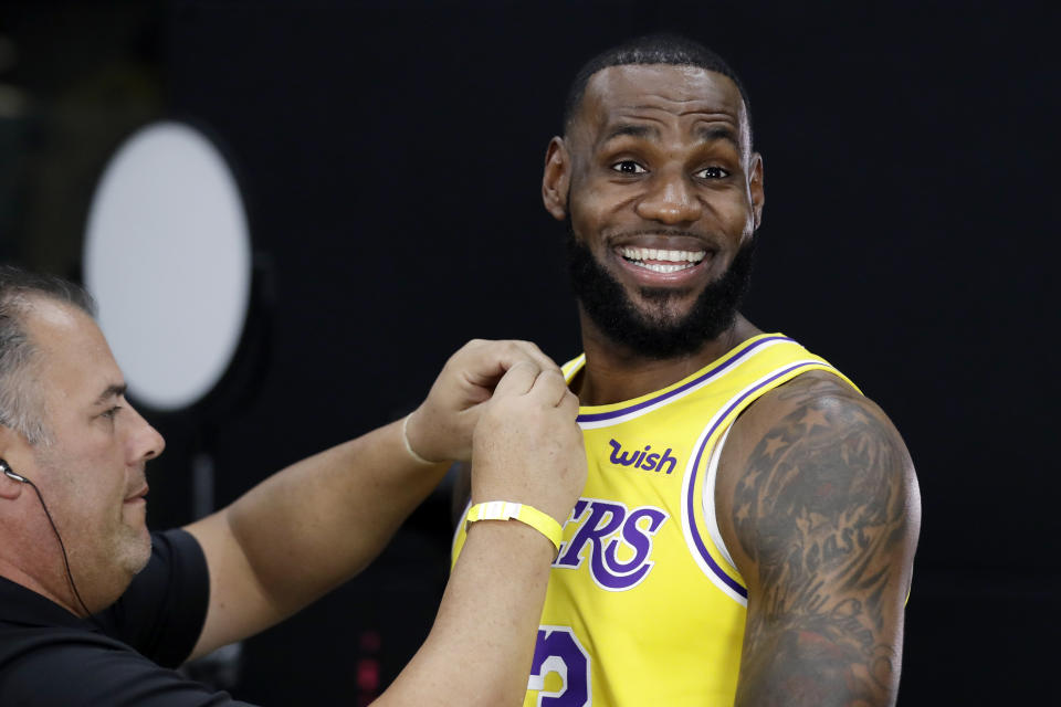 LeBron James, de los Lakers de Los Ángeles, sonríe mientras se le coloca un micrófono durante el Día de Prensa del equipo, el lunes 24 de septiembre de 2018, en El Segundo, California (AP Foto/Marcio José Sánchez)