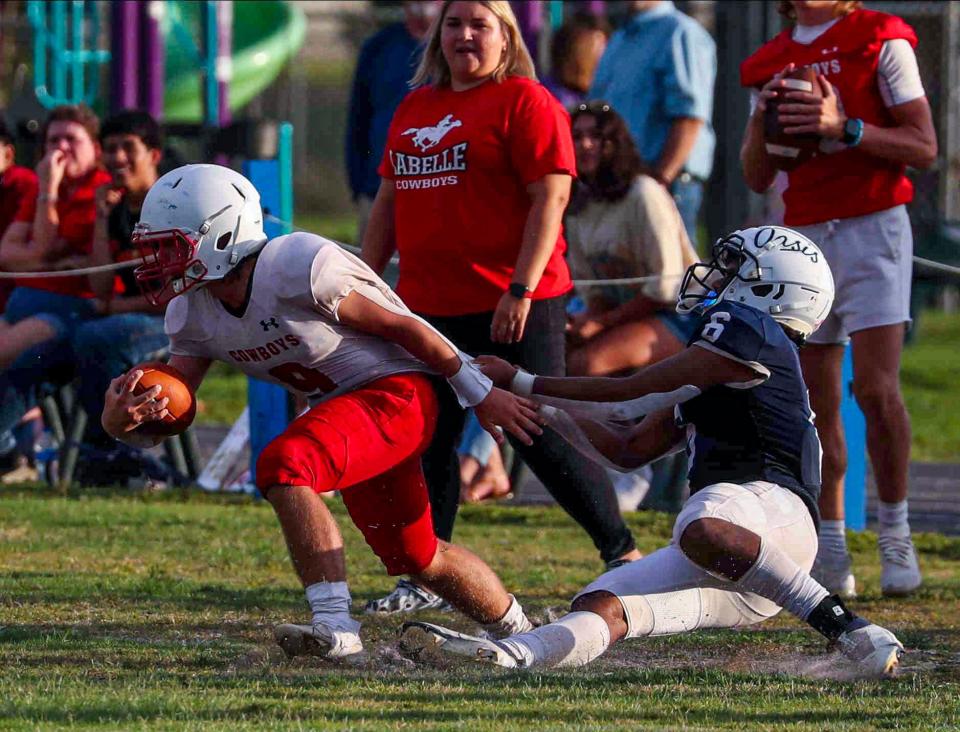 LaBelle's Wyatt Milks is pulley's down by his jersey by Oasis defender Jaxon McArdle-Sykes. LaBelle at Oasis for their spring football game. They played at Caloosa Middle School, Wednesday nigh, May 25, 2022.