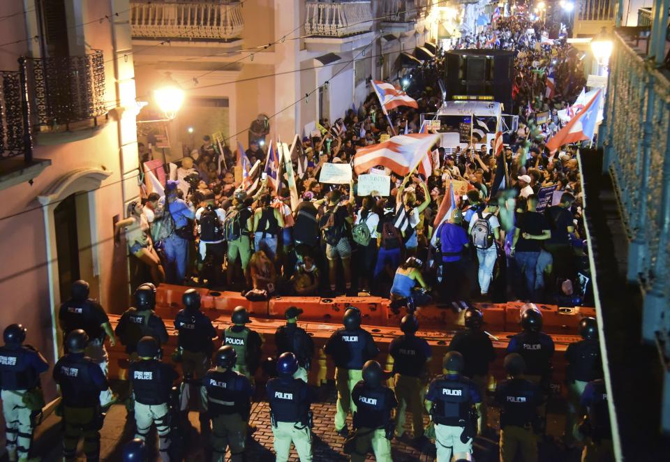 Demonstrators protest against governor Ricardo Rossello, in San Juan, Puerto Rico, Friday, July 19, 2019. Protesters are demanding Rossello step down for his involvement in a private chat in which he used profanities to describe an ex-New York City councilwoman and a federal control board overseeing the island's finance. (AP Photo/Carlos Giusti)