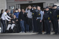 Lansdowne Police Officer David Schiazza, second form left, who was injured while responding to reported standoff the previous day, is saluted as he leaves a hospital in Philadelphia, Thursday, Feb. 8, 2024. (Jose F. Moreno/The Philadelphia Inquirer via AP)