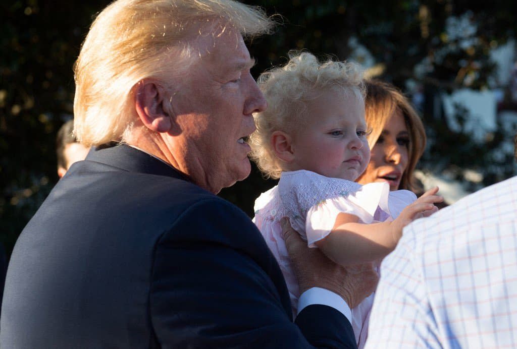 Donald Trump portant un bébé lors d'un pique-nique à la Maison-Blanche en juin 2019. - Saul Loeb