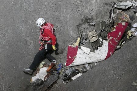 A French rescue worker inspects the remains of the Germanwings Airbus A320 at the site of the crash, near Seyne-les-Alpes, French Alps March 29, 2015. REUTERS/Gonzalo Fuentes