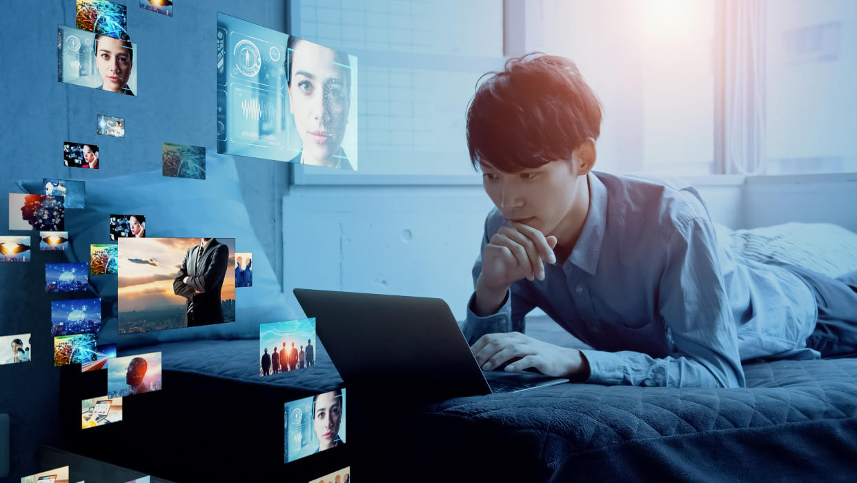  Young man on his laptop looking at images and videos 