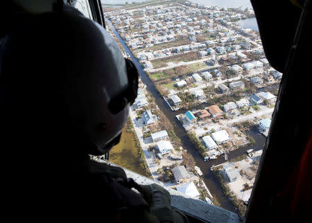 FILE PHOTO: Naval Air Crewman (Helicopter) 3rd Class Austin Rivera, from Fayetteville, N.C., surveys damage caused by Hurricane Irma in the Florida Keys, Florida, U.S. in this handout photo obtained by Reuters on September 15, 2017. Mass Communication Specialist 2nd Class Kristopher Ruiz/U.S. Navy/Handout via REUTERS