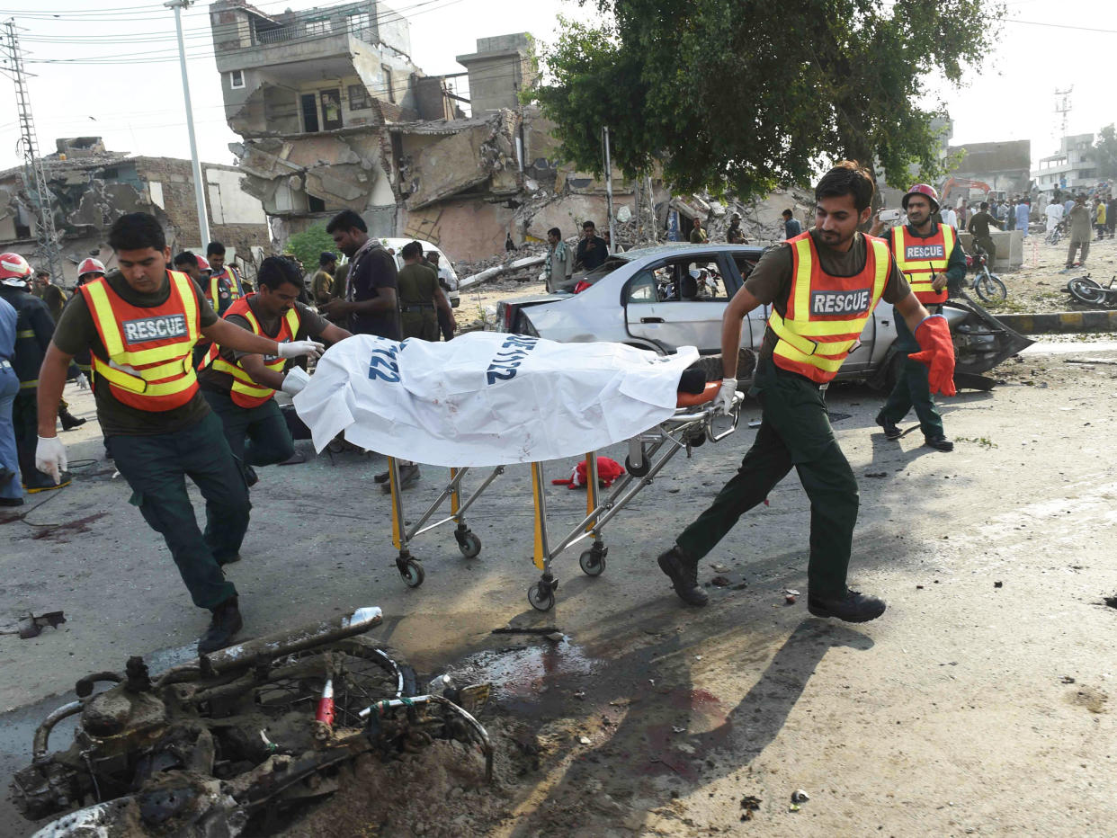 Pakistani rescue workers move the body of a victim at the site of the explosion: AFP