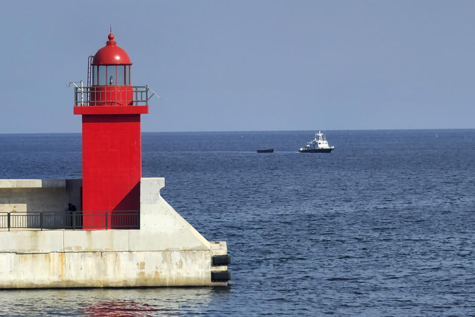 A small wooden boat, center, is towed into a port in Yangyang, South Korea, Tuesday, Oct. 24, 2023. Four suspected North Korean defectors were found in the small wooden boat near the two Koreas' sea border Tuesday, South Korean officials said. (Park Young-seo/Yonhap via AP)