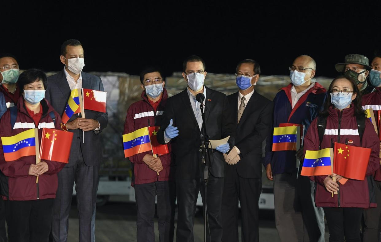 <span class="caption">Venezuela Foreign Minister Jorge Arreaza, center, greets the arrival of medical specialists and supplies from China in March.</span> <span class="attribution"><span class="source">AP Photo/Matias Delacroix</span></span>