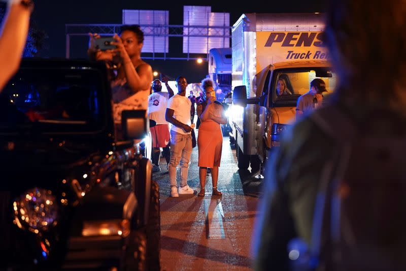 Bystanders use their cell phones to video police as they detain protesters for blocking traffic during a rally against racial inequality and the police shooting death of Rayshard Brooks, in Atlanta