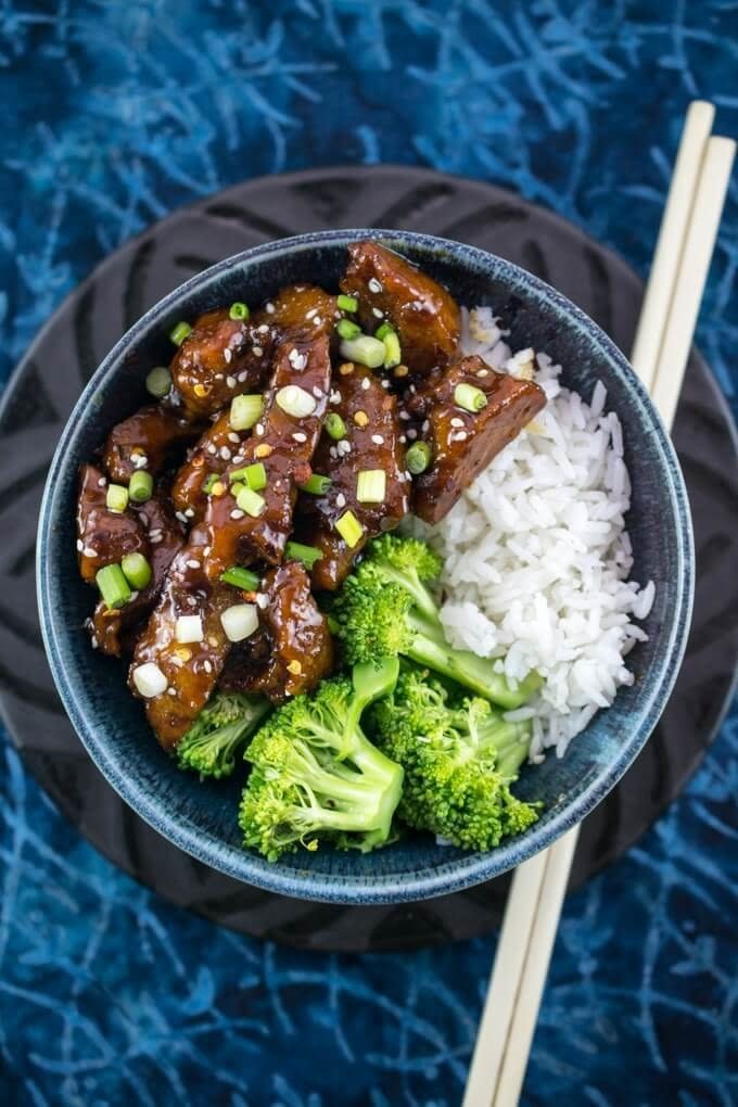 Bowl of sticky, sweet Mongolian seitan and broccoli, with serving of white rice.