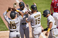 Pittsburgh Pirates' Erik Gonzalez, second from left, celebrates with teammates after hitting a grand slam during the ninth inning of a baseball game against the Cincinnati Reds at Great American Ball Park in Cincinnati, Wednesday, April 7, 2021. (AP Photo/Bryan Woolston)