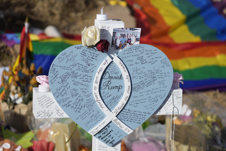 Hand-written messages cover the heart attached to the cross to honor a victim of the mass shooting at a gay nightclub at a makeshift memorial near the scene of the crime Wednesday, Nov. 23, 2022, in Colorado Springs, Colo. The alleged shooter facing possible hate crime charges in the fatal shooting of five people at a Colorado Springs gay nightclub is scheduled to make their first court appearance Wednesday from jail after being released from the hospital a day earlier. (AP Photo/David Zalubowski)