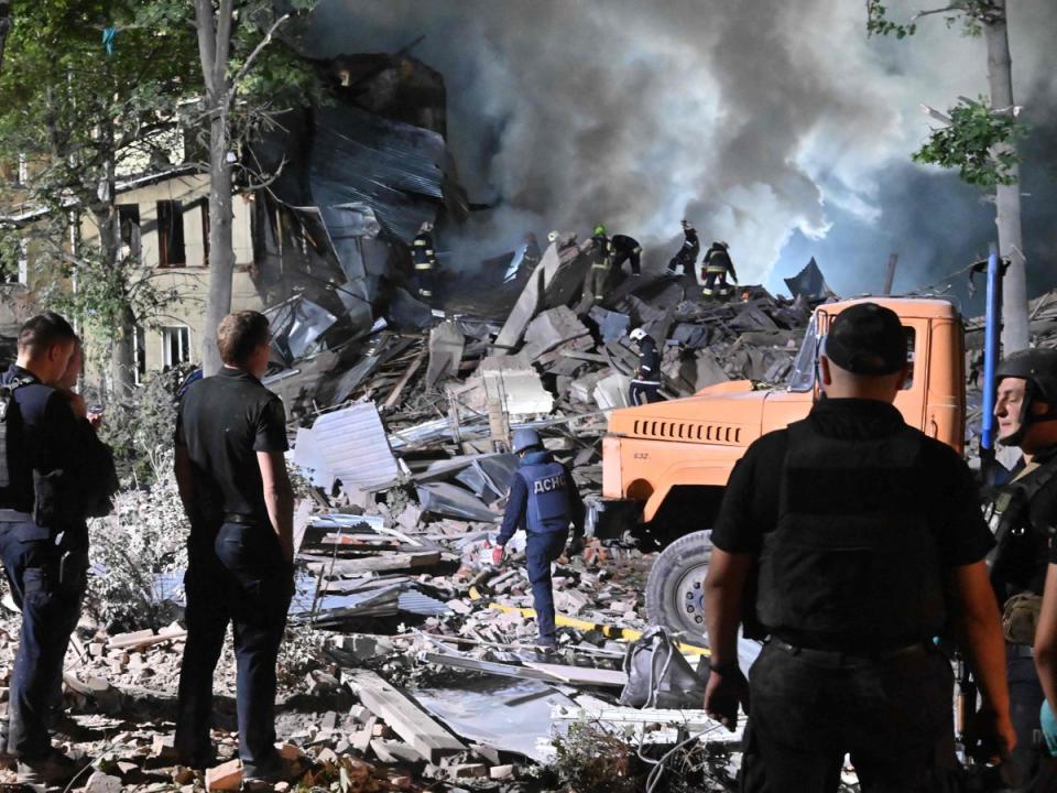 Rescue workers inspect the site of a destroyed hostel in Kharkiv (Sergey Bobok/AFP via Getty Images)