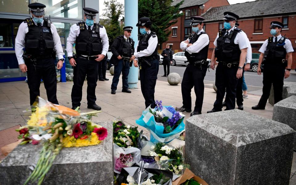 Police officers wearing protective face masks, pay their respects outside the Croydon Custody Centre - DANIEL LEAL-OLIVAS/AFP via Getty Images