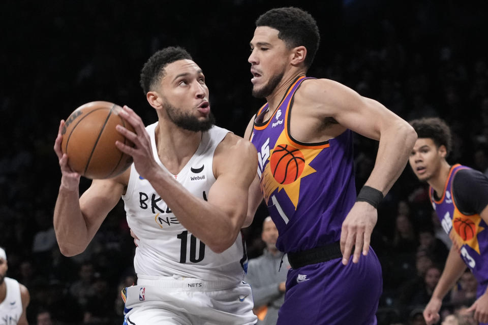 Brooklyn Nets guard Ben Simmons (10) drives against Phoenix Suns guard Devin Booker (1) during the first half of an NBA basketball game, Tuesday, Feb. 7, 2023, in New York. (AP Photo/Mary Altaffer)