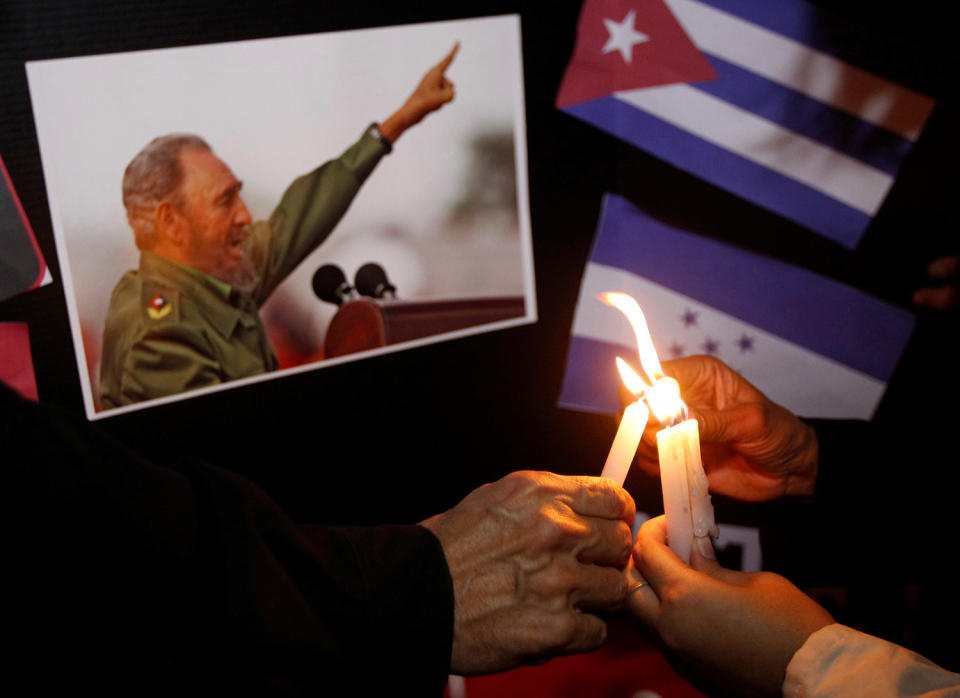 People place candles beside a picture of Fidel Castro