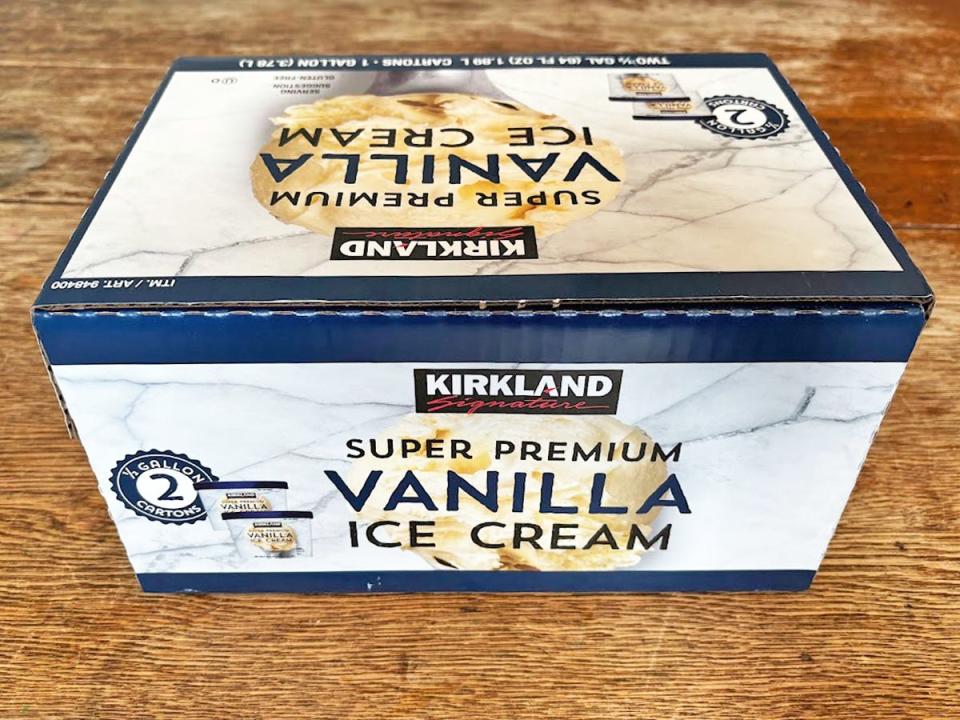 A large light-blue box of Kirkland Signature vanilla ice cream with the Kirkland Signature logo on the front of it. The box has a picture of a scoop of ice cream and dark-blue detailing