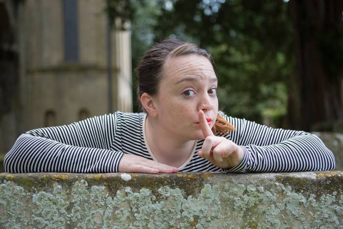 A young girl shushing with her finger over her lips