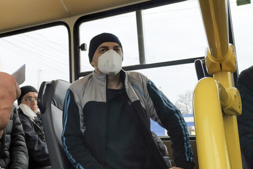 Separatist war prisoners, some of them wearing face masks to protect against coronavirus, sit in a bus after they were exchanged near the checkpoint Horlivka, eastern Ukraine, Thursday, April 16, 2020. Ukrainian forces and Russia-backed rebels in eastern Ukraine have begun exchanging prisoners in a move aimed at ending their five-year long war.(AP Photo/Alexei Alexandrov)