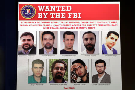 Pictures of nine Iranians charged with conducting massive cyber theft campaign are seen on display during Deputy Attorney General Rod Rosenstein's news conference at the Justice Department in Washington, U.S., March 23, 2018. Department of Justice/Handout via REUTERS