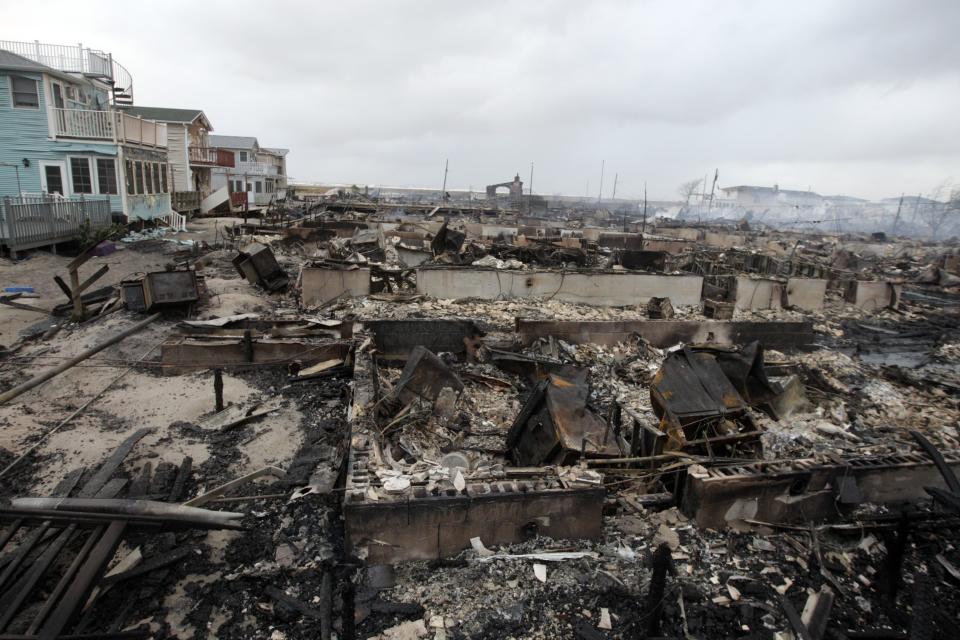 Homes destroyed by a fire at Breezy Point are shown, in the New York City borough of Queens Tuesday, Oct. 30, 2012, in New York. The fire destroyed between 80 and 100 houses Monday night in the flooded neighborhood. More than 190 firefighters have contained the six-alarm blaze fire, but they are still putting out some pockets of fire. (AP Photo/Frank Franklin II)