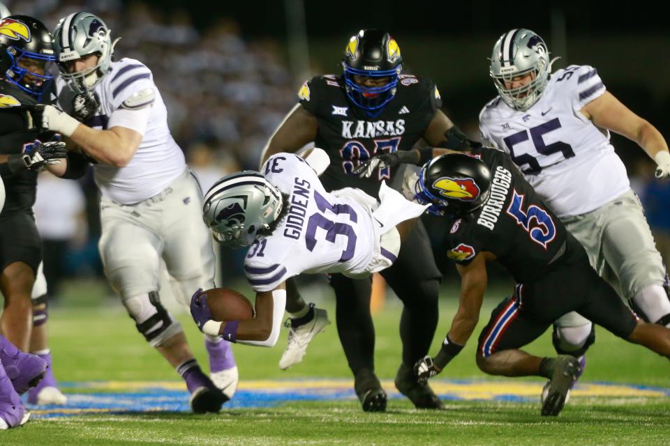 Kansas' O.J. Burroughs (5) brings down Kansas State running back DJ Giddens during the second quarter of Saturday's Sunflower Showdown inside David Booth Kansas Memorial Stadium.