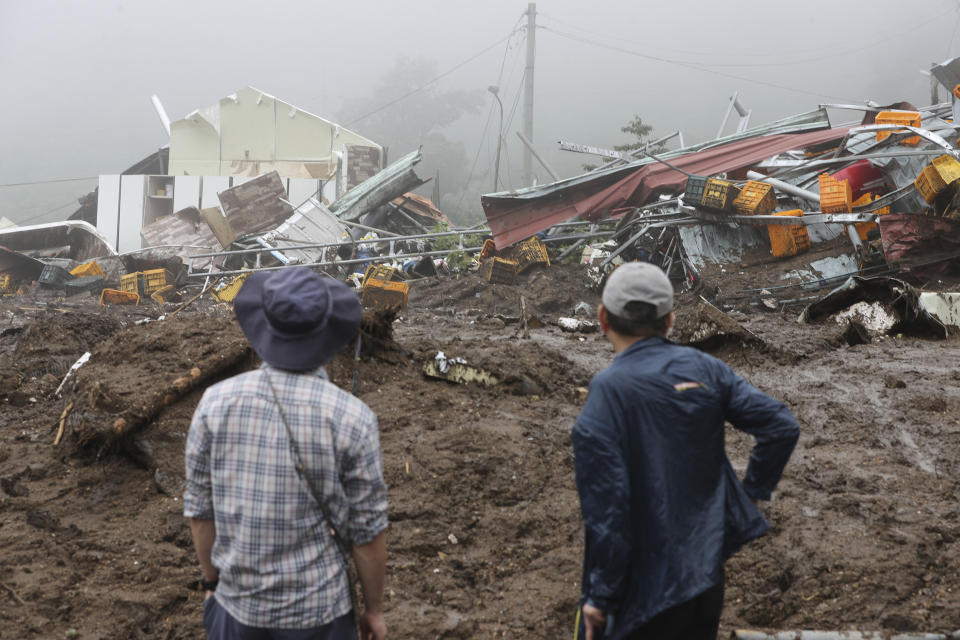 People watch their collapsed houses after a landslide caused by heavy rain in Yecheon, South Korea, Sunday, July 16, 2023. Days of heavy rain triggered flash floods and landslides and destroyed homes, leaving scores of people dead and forcing thousands to evacuate, officials said Sunday. (Yun Kwan-shick/Yonhap via AP)