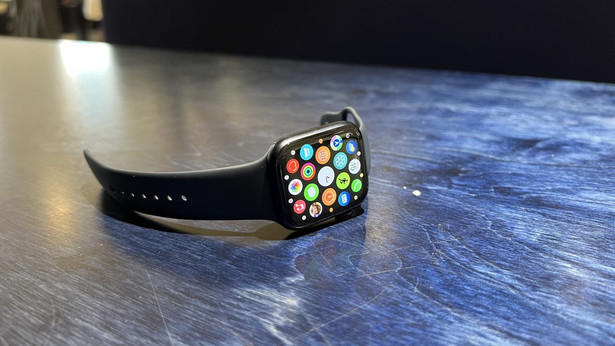  The Apple WAtch 8 on a blue desk and wrist 