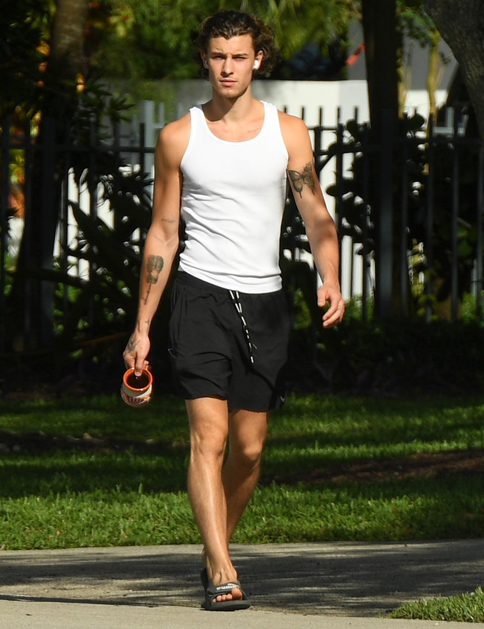 <p>Shawn Mendes steps out from girlfriend Camila Cabello's house in Miami on Thursday, wearing a white tank and shorts.</p>