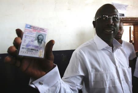 George Weah, former soccer player and presidential candidate of Congress for Democratic Change (CDC) shows his voter's card at a polling station in Monrovia, Liberia October 10, 2017. REUTERS/Thierry Gouegnon