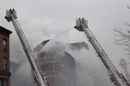 New York City Fire Department firefighters battle fire at the site of a residential apartment building collapse and fire in New York City's East Village neighborhood, March 26, 2015. REUTERS/Brendan McDermid