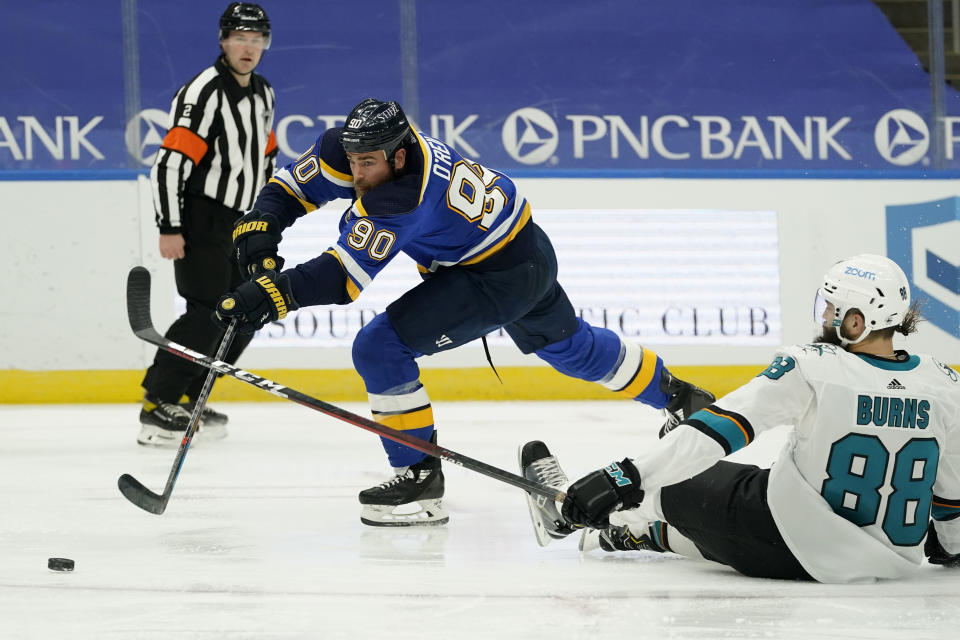 St. Louis Blues' Ryan O'Reilly (90) passes around San Jose Sharks' Brent Burns (88) during the second period of an NHL hockey game Monday, Jan. 18, 2021, in St. Louis. (AP Photo/Jeff Roberson)