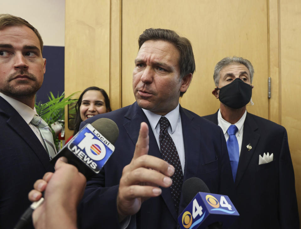 Florida Gov. Ron DeSantis responds to local TV reporter's question after he signed legislation seeking to punish social media platforms that remove conservative ideas from their sites at Florida International University's's MARC building in Miami on Monday, May 24, 2021. (Carl Juste/Miami Herald via AP)