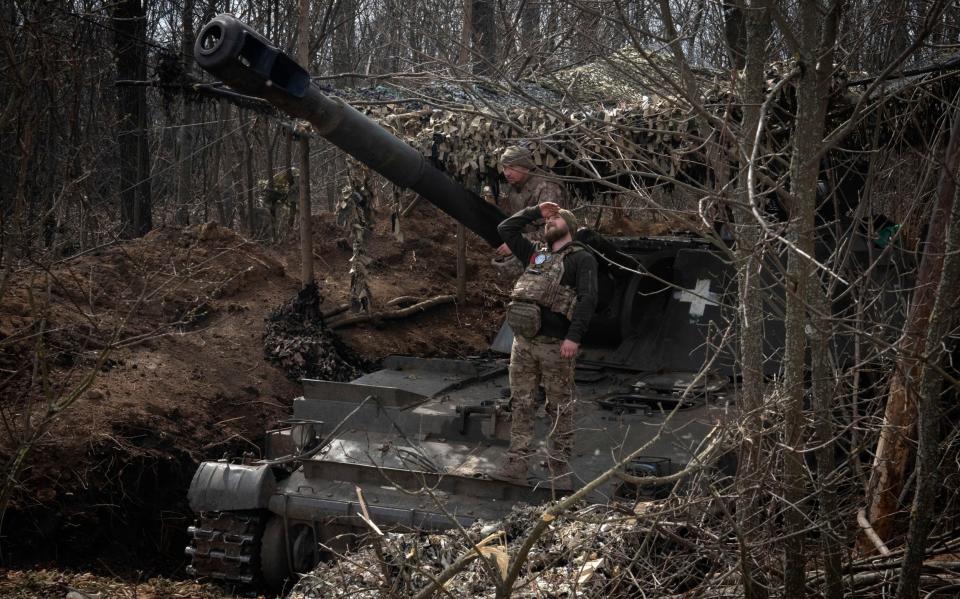 A Ukrainian soldier looking for a visual confirmation of drone-free sky, as he prepares to fire 152-mm Self-Propelled Howitzer 2S3