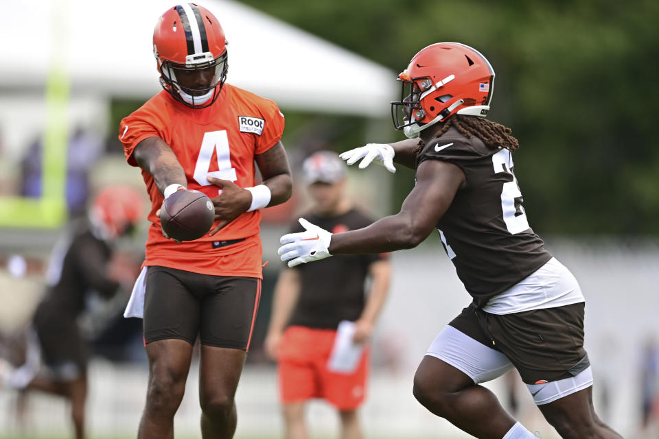 Cleveland Browns quarterback Deshaun Watson, left, hands off to running back Kareem Hunt during an NFL football practice in Berea, Ohio, Sunday, Aug. 7, 2022. (AP Photo/David Dermer)