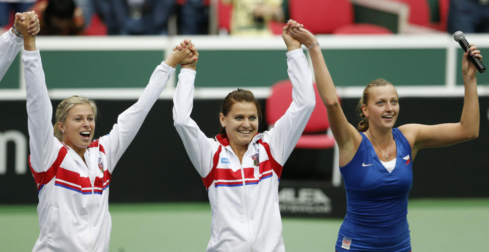 Czech Republic's Petra Kvitova, right, celebrates with her teammates Lucie Safarova, center, and Andrea Hlavackova, left, after defeating Italy's Roberta Vinci in their Fed Cup semifinal tennis match in Ostrava, Czech Republic, Sunday, April 20, 2014. Kvitova won the match and gave Czech Republic a decisive 3-0 lead. (AP Photo/Petr David Josek)