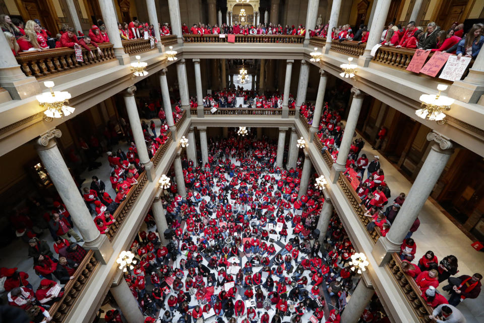 Thousands of Indiana teachers wearing red hold rally at the Statehouse in Indianapolis, Tuesday, Nov. 19, 2019, calling for further increasing teacher pay in the biggest such protest in the state amid a wave of educator activism across the country. Teacher unions says about half of Indiana's nearly 300 school districts are closed while their teachers attend Tuesday's rally while legislators gather for 2020 session organization meetings.(AP Photo/Michael Conroy)