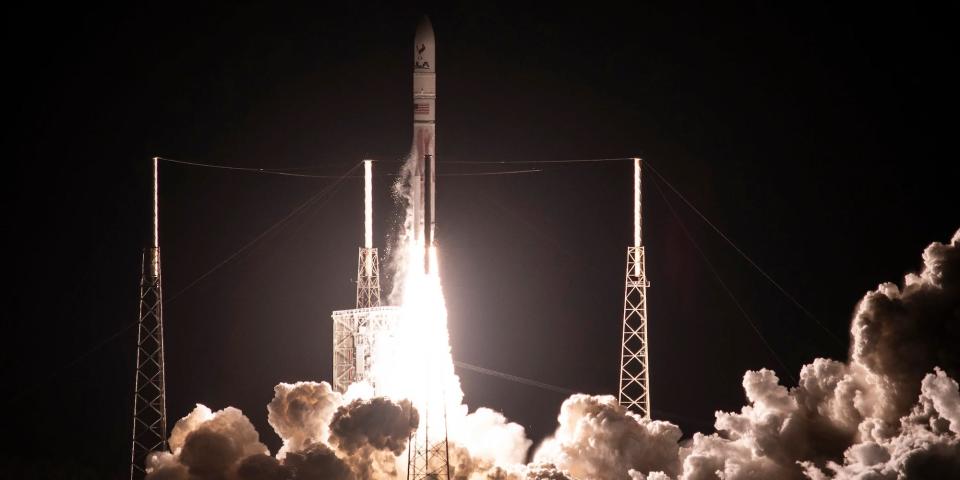 A rocket is seen taking off from a launchpad at night.